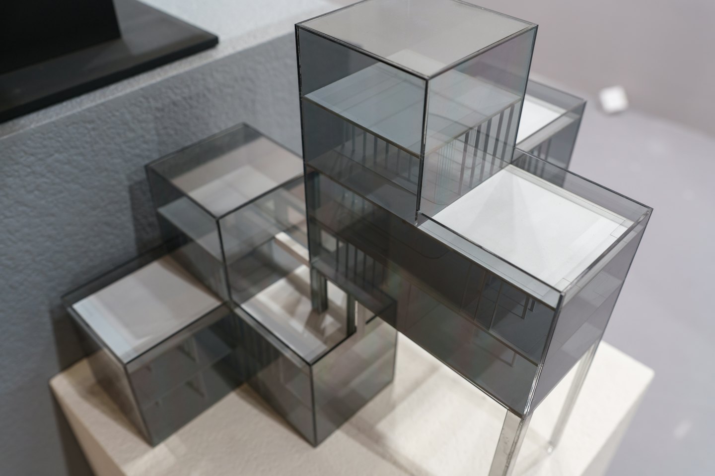 An acrylic architectural model of a cuboid building with stairs.