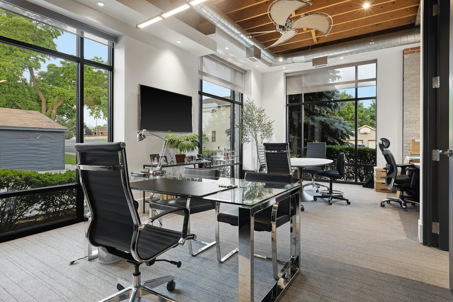 Modern office with glass desks and ergonomic chairs.